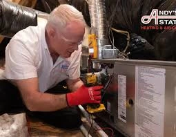 Technician wearing red gloves inspecting a furnace