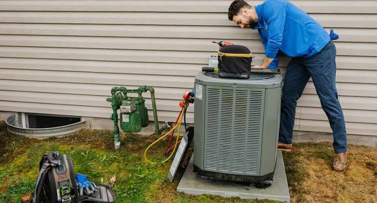 HVAC technician performing maintenance on an outdoor condenser
